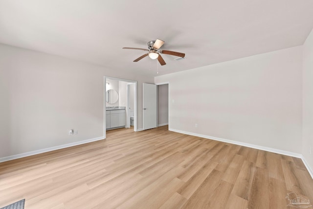 unfurnished bedroom featuring ensuite bathroom, light wood finished floors, baseboards, visible vents, and a ceiling fan