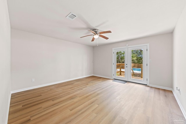 spare room featuring light wood-style floors, a ceiling fan, visible vents, baseboards, and french doors