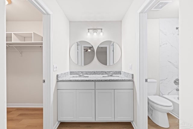 full bath with visible vents, wood finished floors, toilet, and a sink