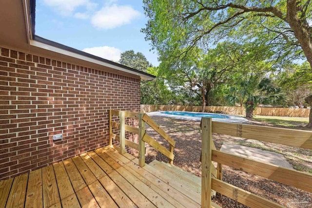 wooden deck featuring a fenced backyard and a fenced in pool