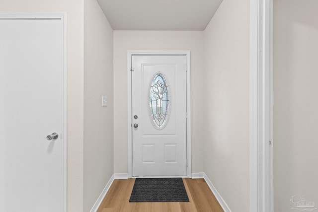 doorway with light wood-style floors and baseboards