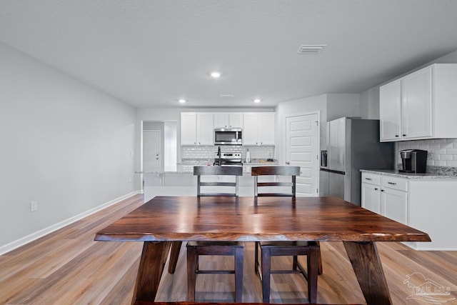 10985 Blacktail Loop, Pensacola, FL 32526 - kitchen featuring appliances with stainless steel finishes, tasteful backsplash, white cabinets, baseboards, and recessed lighting