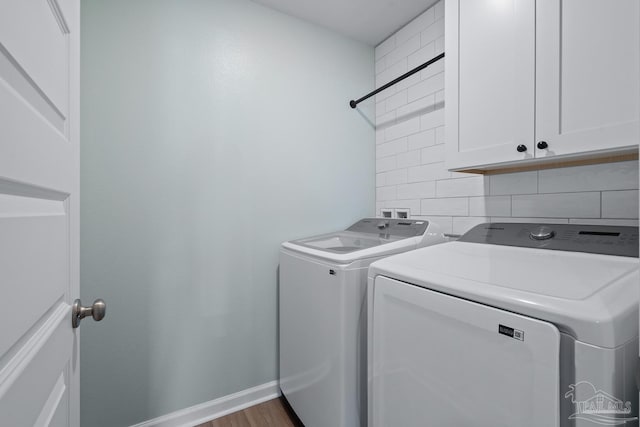 10985 Blacktail Loop, Pensacola, FL 32526 - clothes washing area with independent washer and dryer, cabinet space, baseboards, and wood finished floors
