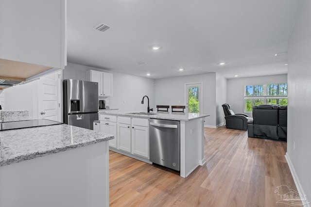 10985 Blacktail Loop, Pensacola, FL 32526 - kitchen with stainless steel appliances, a sink, light wood-style floors, white cabinetry, and recessed lighting