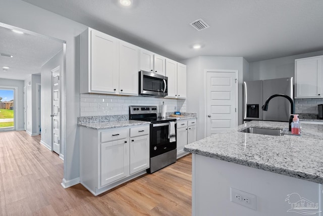 10985 Blacktail Loop, Pensacola, FL 32526 - kitchen featuring appliances with stainless steel finishes, a sink, light wood-style flooring, tasteful backsplash, and recessed lighting
