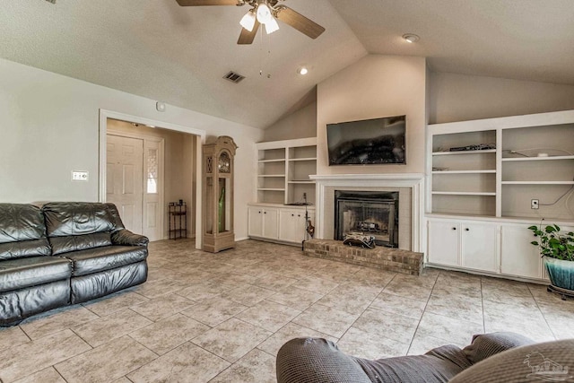 living room with ceiling fan, a textured ceiling, vaulted ceiling, built in features, and a fireplace