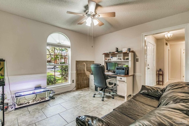 office area featuring a textured ceiling, light tile patterned floors, and ceiling fan