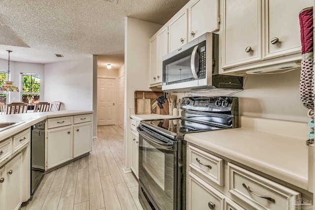 kitchen with a textured ceiling, black appliances, light wood-type flooring, and pendant lighting