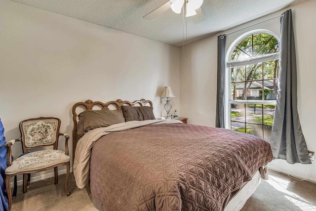 bedroom with a textured ceiling, carpet, and ceiling fan