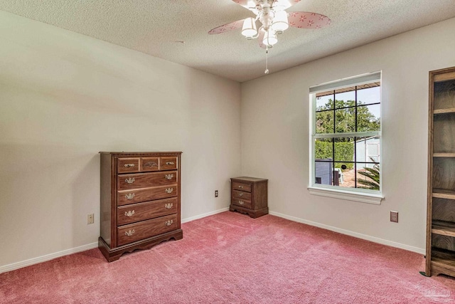 interior space featuring a textured ceiling, carpet, and ceiling fan