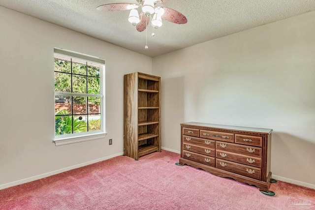 unfurnished bedroom featuring light carpet, a textured ceiling, and ceiling fan