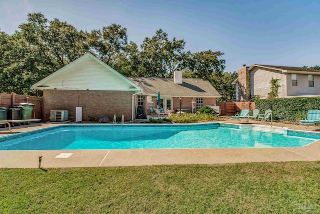 view of pool featuring central air condition unit, a patio area, and a lawn