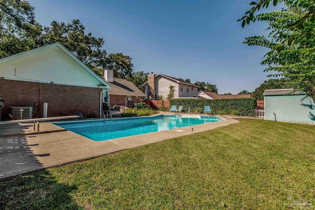 view of swimming pool with a patio, a shed, central air condition unit, and a lawn