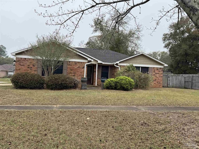 ranch-style house featuring brick siding, a front lawn, and fence