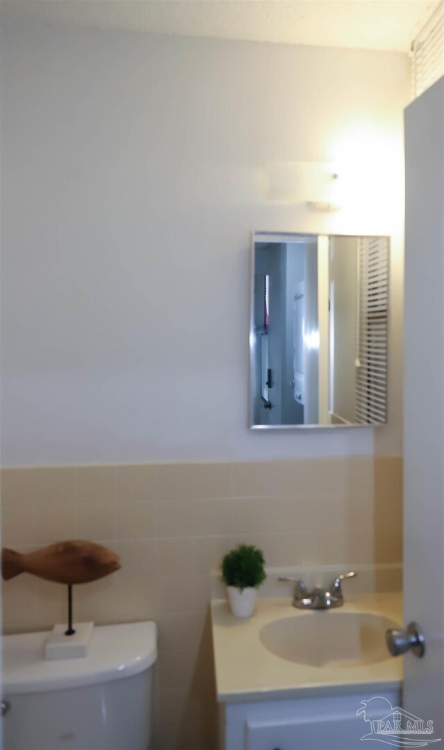 bathroom featuring vanity, tile walls, tasteful backsplash, and toilet