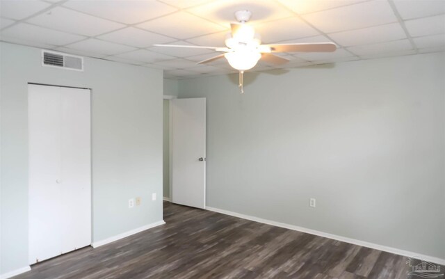 unfurnished bedroom featuring a drop ceiling, hardwood / wood-style floors, and ceiling fan