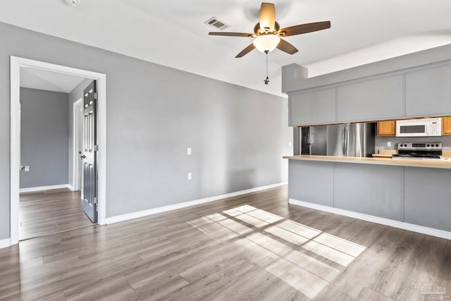 unfurnished living room featuring ceiling fan and dark hardwood / wood-style flooring