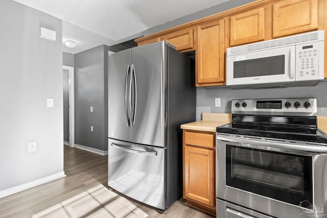 kitchen featuring stainless steel appliances and light hardwood / wood-style flooring