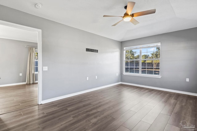 spare room with lofted ceiling, dark wood-type flooring, and ceiling fan