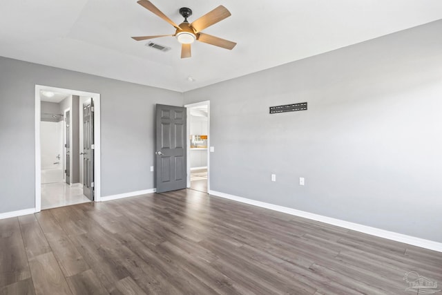 unfurnished bedroom with ceiling fan, ensuite bath, and dark hardwood / wood-style flooring