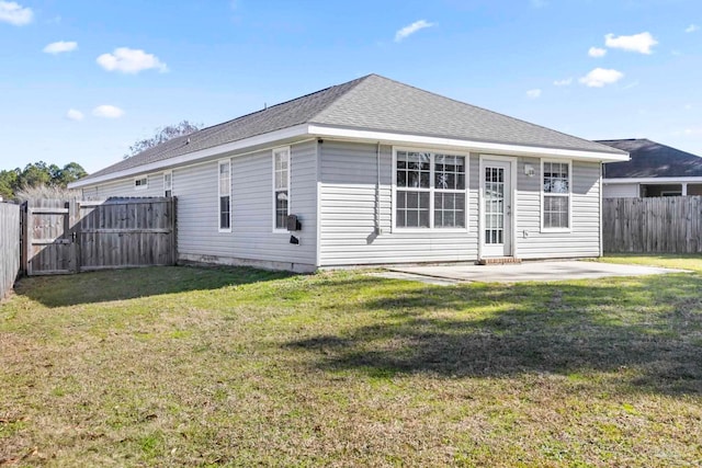 back of property with a lawn and a patio