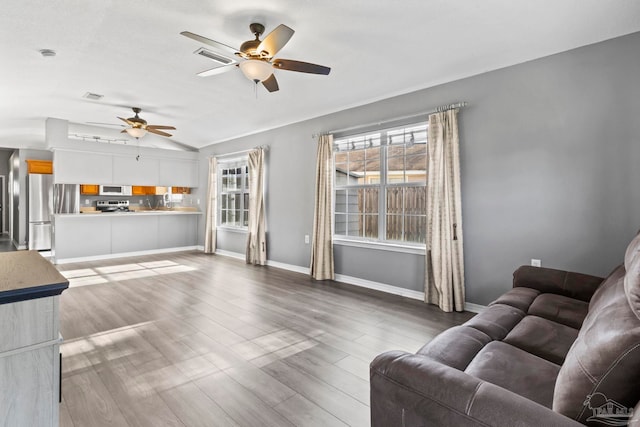 living room with vaulted ceiling, hardwood / wood-style floors, and ceiling fan