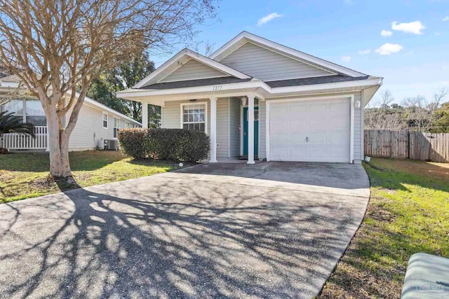 view of front of property with a garage, cooling unit, and a front lawn