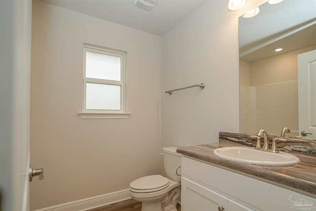 bathroom with vanity, a textured ceiling, a shower, wood-type flooring, and toilet