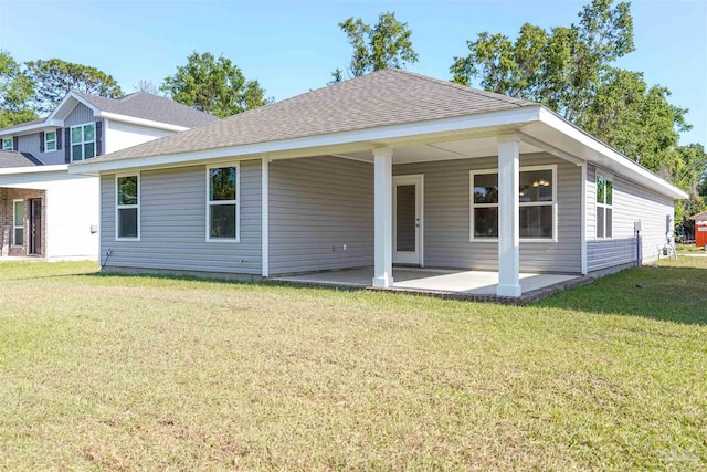 rear view of house with a lawn and a patio