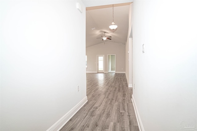 corridor with lofted ceiling and hardwood / wood-style flooring