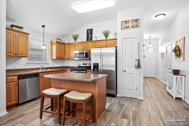 3966 Willow Glen Dr, Pace, FL 32571 - kitchen with a center island, wood finished floors, vaulted ceiling, and stainless steel appliances