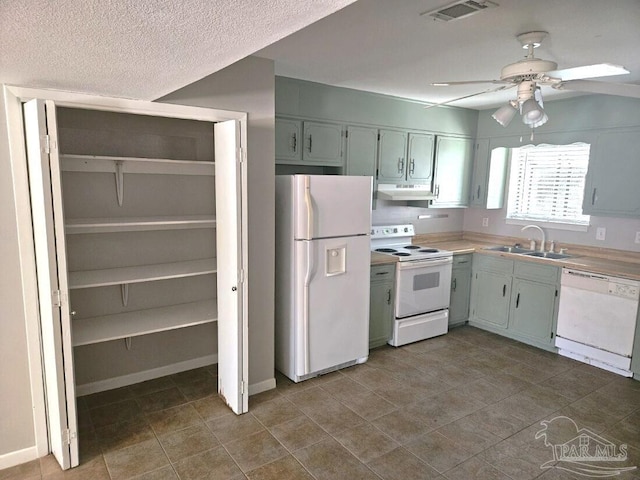 kitchen with white appliances, under cabinet range hood, a sink, visible vents, and a ceiling fan