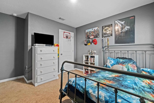 bedroom featuring light colored carpet, visible vents, a textured ceiling, and baseboards