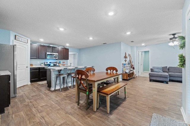 dining area featuring a textured ceiling, visible vents, recessed lighting, light wood finished floors, and a ceiling fan