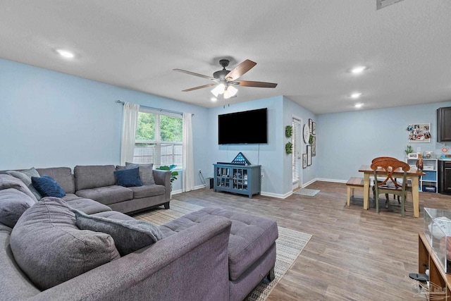 living area with ceiling fan, recessed lighting, light wood-style flooring, and baseboards