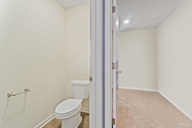 bathroom with toilet and baseboards