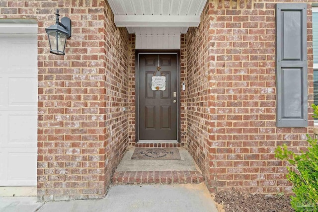 view of exterior entry with brick siding