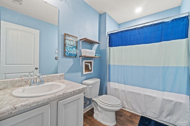 bathroom featuring vanity, toilet, visible vents, baseboards, and wood finished floors