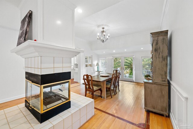 dining room with light hardwood / wood-style floors, crown molding, and an inviting chandelier