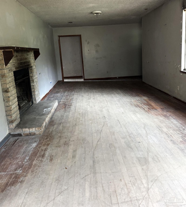 unfurnished living room with wood-type flooring and a textured ceiling