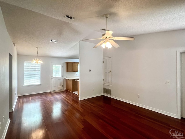 5538 Rowell Rd, Milton, FL 32583 - unfurnished living room featuring dark wood-type flooring, baseboards, ceiling fan, a chandelier, and a textured ceiling
