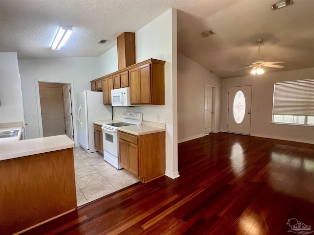5538 Rowell Rd, Milton, FL 32583 - kitchen featuring white appliances, vaulted ceiling, light wood-style flooring, light countertops, and a ceiling fan