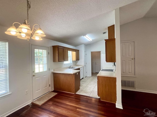 5538 Rowell Rd, Milton, FL 32583 - kitchen with vaulted ceiling, a sink, a chandelier, a textured ceiling, and light countertops