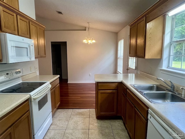 5538 Rowell Rd, Milton, FL 32583 - kitchen featuring white appliances, a sink, lofted ceiling, a chandelier, and a peninsula