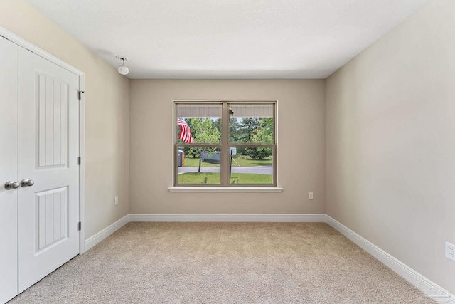 unfurnished room with light colored carpet