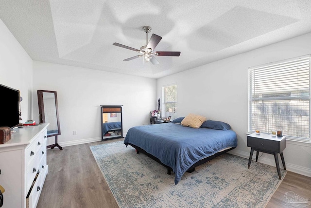 bedroom featuring a textured ceiling, wood finished floors, and baseboards