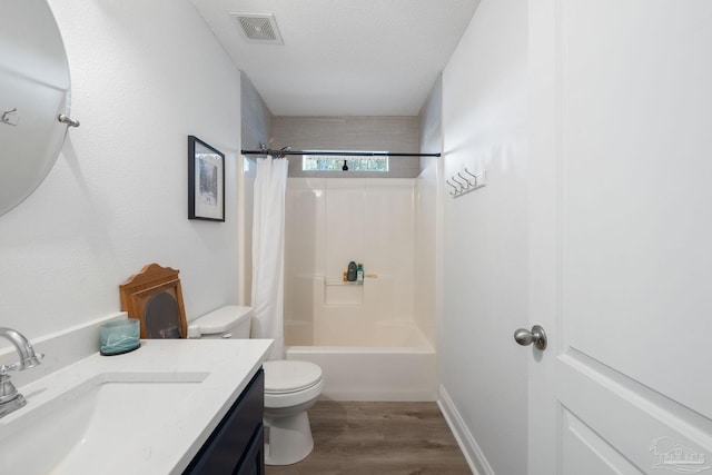 bathroom with visible vents, toilet, vanity, a textured ceiling, and wood finished floors