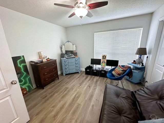 bedroom with baseboards, light wood-style flooring, a ceiling fan, and a textured ceiling