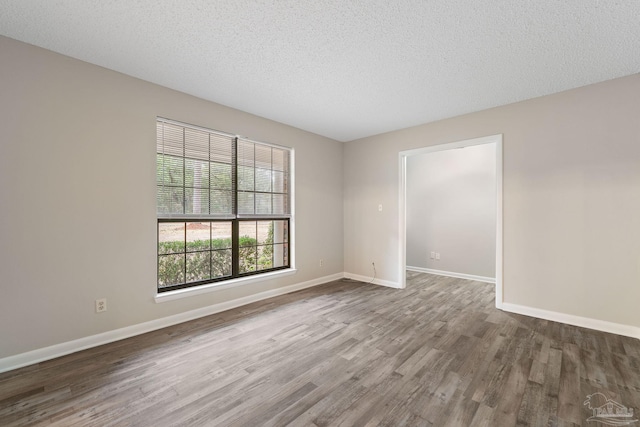 spare room with hardwood / wood-style floors and a textured ceiling