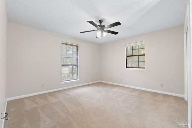 carpeted spare room featuring ceiling fan and a textured ceiling